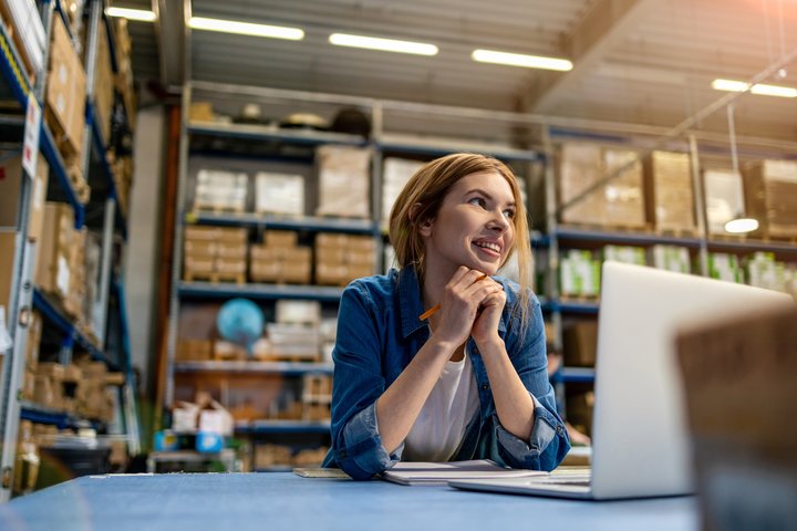 Vrouw werkt op haar laptop in een sorteercentrum